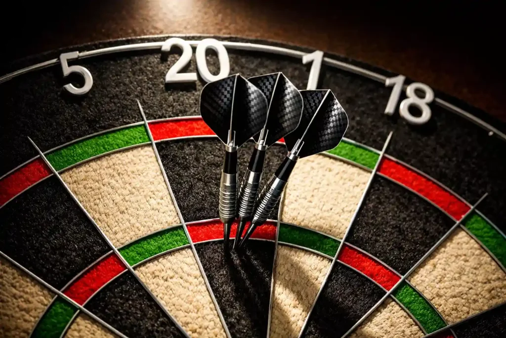 Nahaufnahme einer Dartscheibe mit drei Pfeilen in der Triple-20 unter Spotlicht
